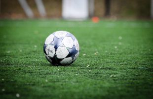 Football on empty grass pitch 