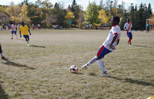 Boys playing football on grass pitch 