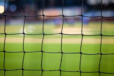 Close up image of sport netting against grass sports pitch. 