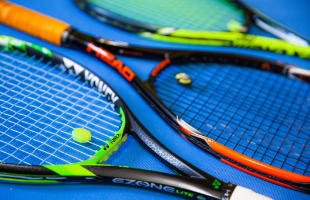 Tennis rackets lined up on floor 
