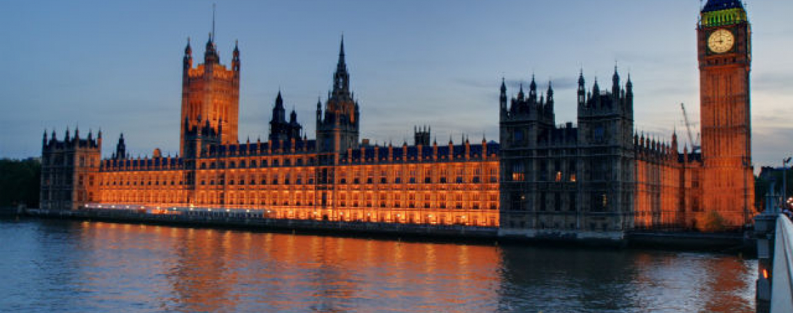A wide angle image of Westminster, the Houses of Parliament and Big Ben in London, captured from the bridge, including the Thames River.  