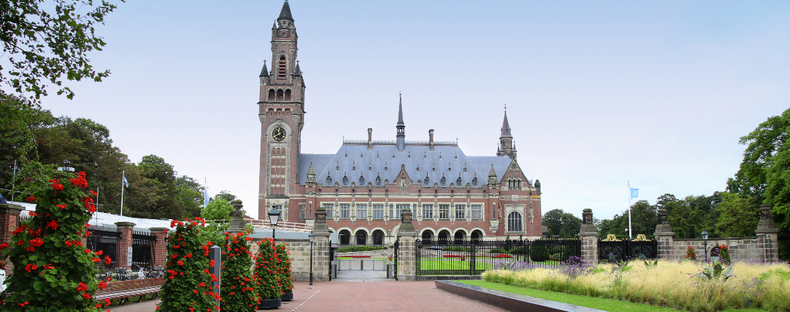 The Peace Palace in the Hague - a 1900s building in red and white brick, with a tall narrow clocktower