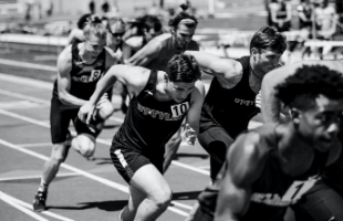 Black and white image of men running on track 