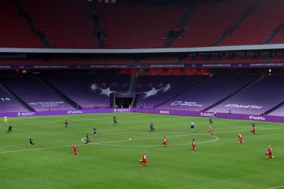 Football players kneeling on grass pitch in football stadium. 