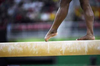 Close up image of athletes feet on balance beam. 
