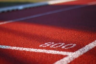 Close up image of white painted lines and number on sports track.